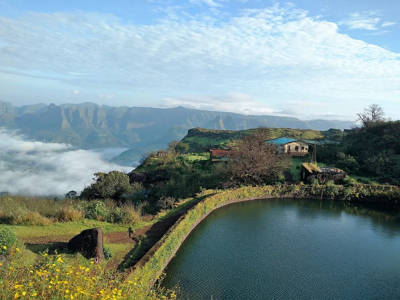 महाराष्ट्र के रायगढ़ किले से दिखता जलाशय, पत्थर का परिसर और दूर तक पहाड़